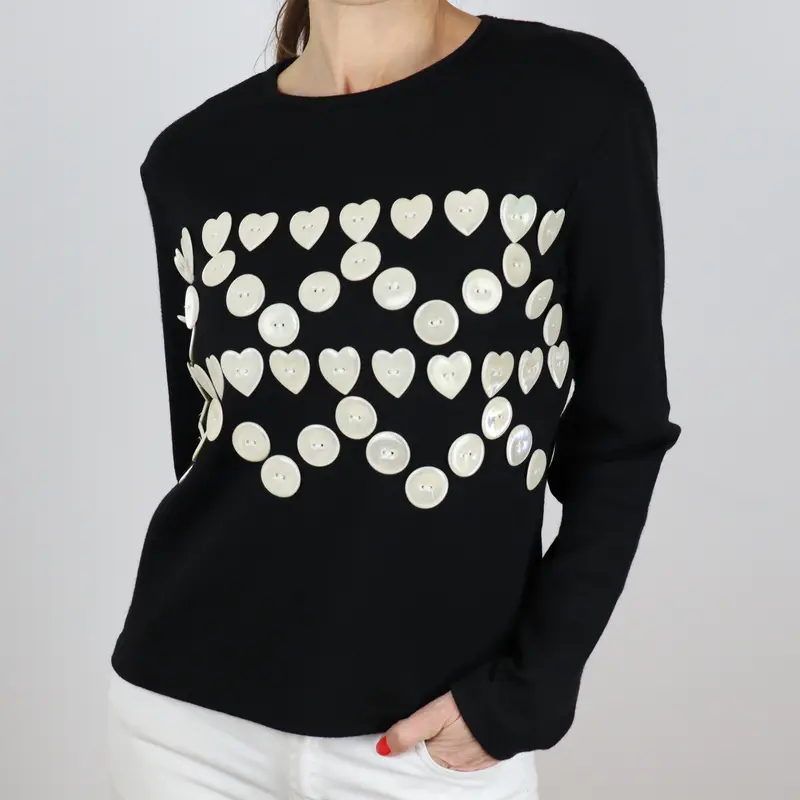 Camiseta negra con botones en forma de corazón blancos